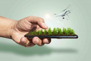 Farmer controls drone with futuristic smartphone. Smart farming and precision agriculture ads. online